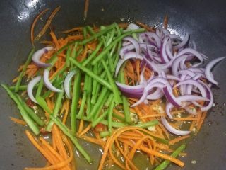 培根彩蔬炒米粉,再放入青尖椒丝与洋葱翻炒。

蔬菜炒到断生即可，不要炒太久。