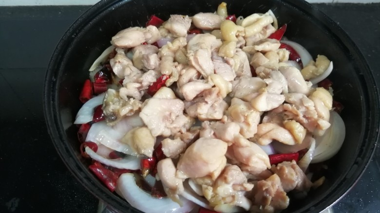 麻辣鸡块,将鸡肉块倒在洋葱上，再撒一点白糖。盖上盖子，中火闷煮到洋葱断生。