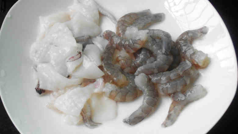 沙茶酱海鲜炒饭,鱿鱼去掉黑皮治净，打花刀的再切小片；虾去壳挑去虾肠虾线