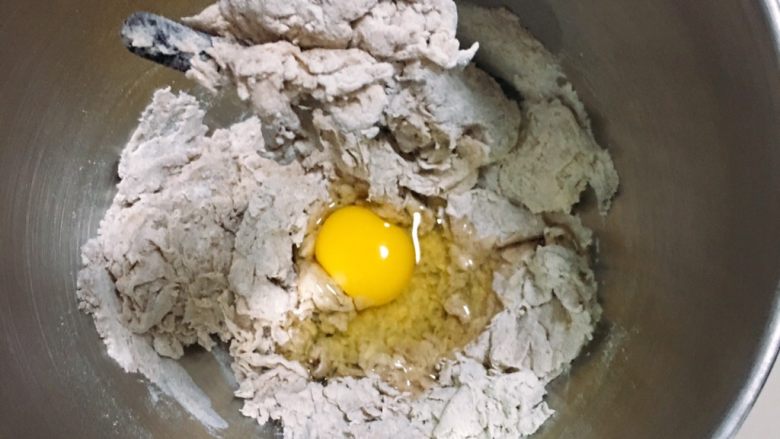 芝麻核桃黑麦包,启动厨师机揉面二分钟后加入鸡蛋。