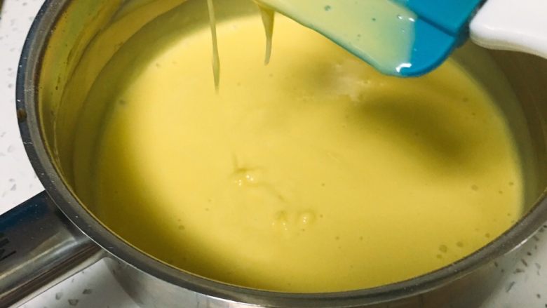 鱼松小蛋糕,先用打蛋器搅打十几秒后再用刮刀拌匀蛋黄糊。