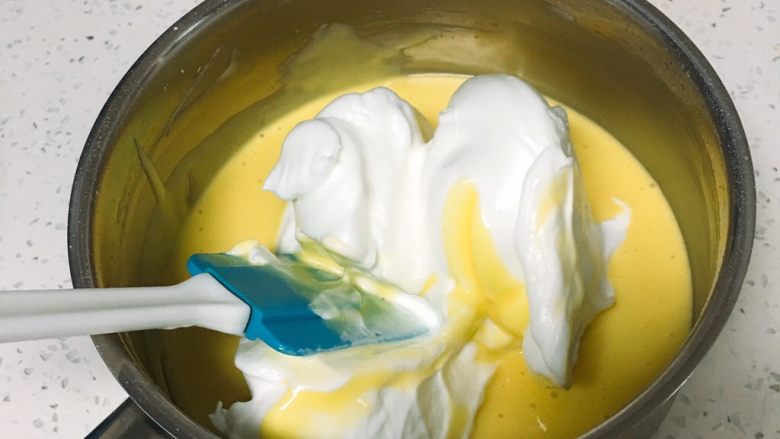 鱼松小蛋糕,取三分之一的蛋白进蛋黄糊中。