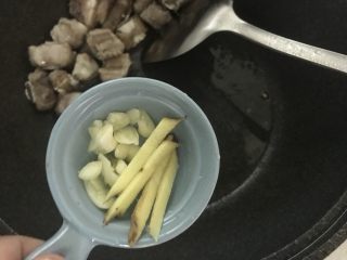 新手菜谱，土豆排骨焖饭,加入姜丝蒜片翻炒。