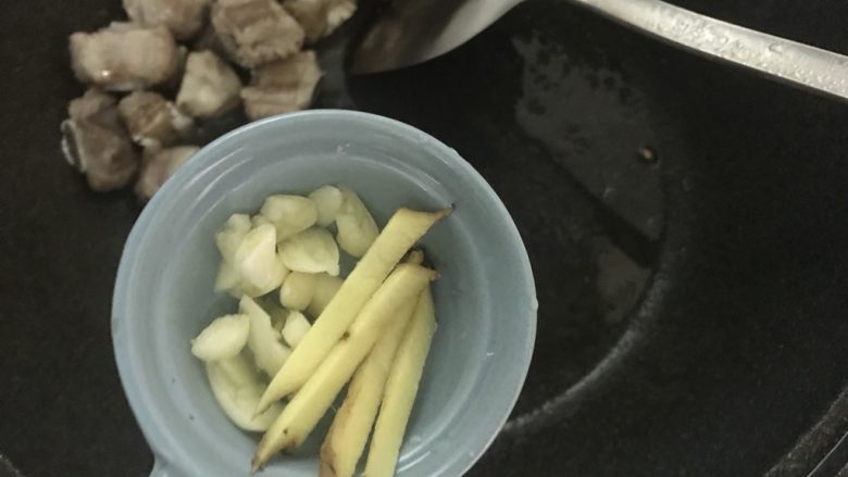 新手菜谱，土豆排骨焖饭,加入姜丝蒜片翻炒。