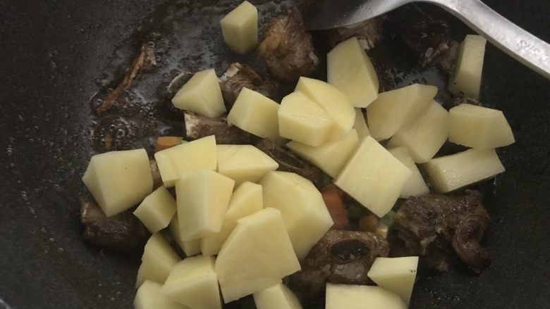 新手菜谱，土豆排骨焖饭,把土豆，杂蔬倒入。翻炒均匀。