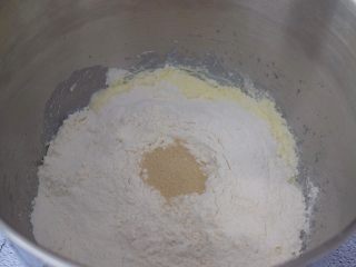 金钱小面包,把材料除了黄油外，都放入和面桶，顺序为纯牛奶、鸡蛋液、糖和盐对角放，然后放奶粉和面粉，酵母放最上面