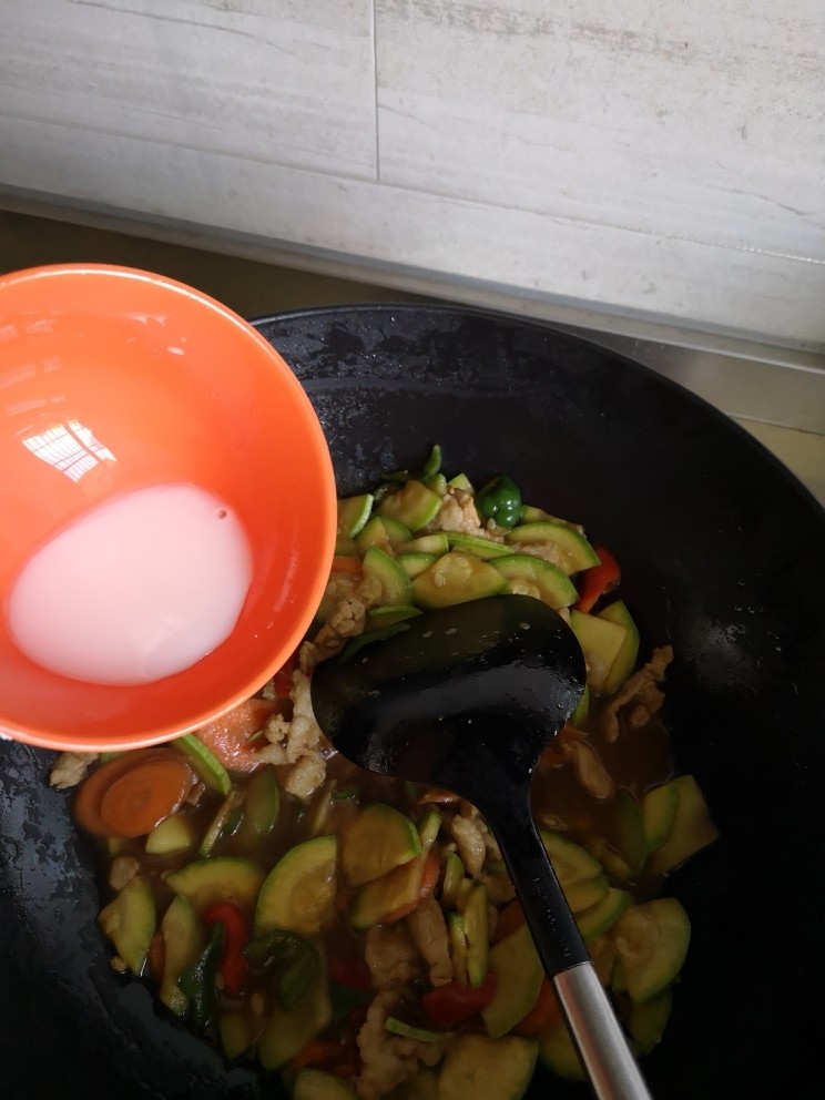 西葫芦炒肉片,淀粉用冷水稀释
倒入锅中
迅速翻炒均匀