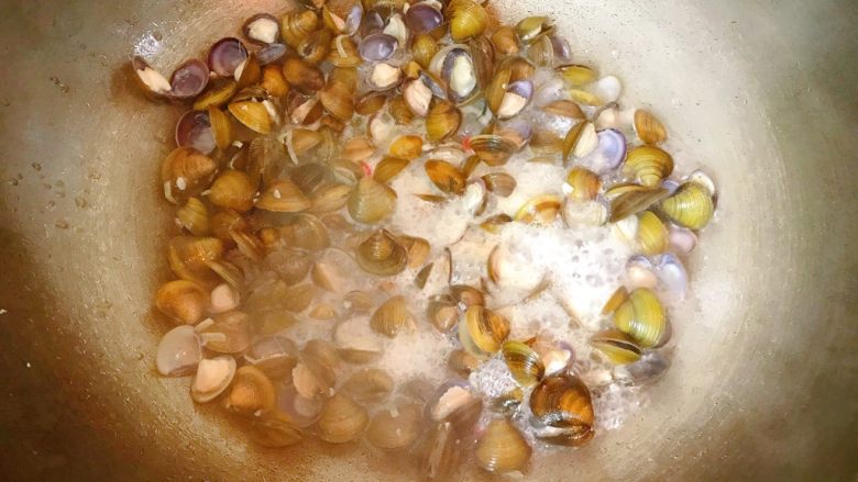 辣炒河蚬,翻炒后会出水，再喷一点点开水，煮至河蚬全开口。