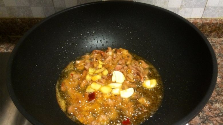 豇豆香干炒肉丝,放入大蒜和生姜片翻炒10秒。