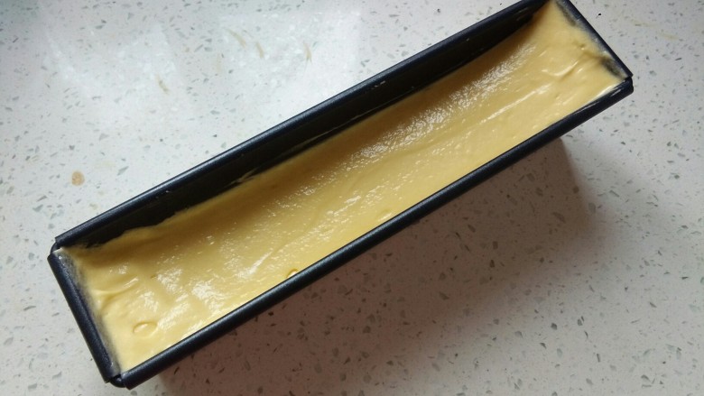 百香果磅蛋糕,将面糊移入模具，用刮刀整理成中间低两边高，放入预热好的烤箱上下管170℃50分钟