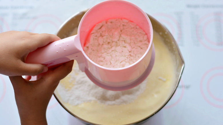 KITTY海绵奶油蛋糕,筛入低筋面粉，（过筛的主要作用是可以去除粉类储存过程中产生的结块，让面粉更蓬松），用手动打蛋器搅拌至面粉无颗粒状