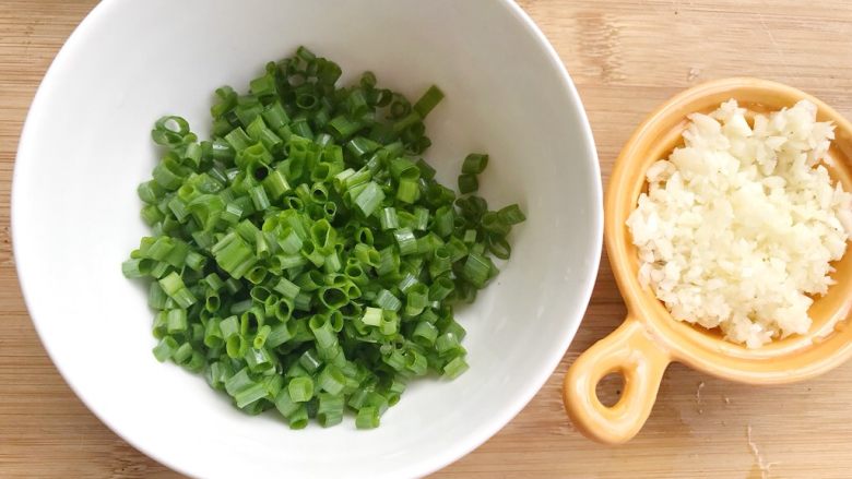 快手早餐蒜香吐司条,葱叶切成葱花，蒜绞成蒜蓉。