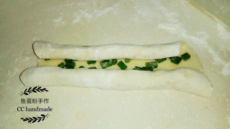 家常葱油饼,5 把面皮从两边向内卷，然后两边搭在一起，形成一个长条。