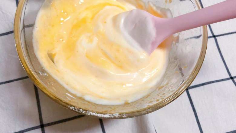 【宝宝辅食】戚风纸杯蛋糕,取1/3的蛋白到蛋黄面糊中，用硅胶刮刀轻轻拌匀