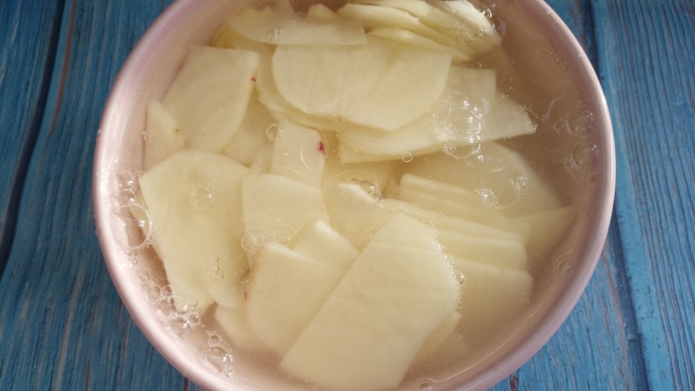 辣白菜土豆片,放在水里泡一下，把土豆中的淀粉泡掉。