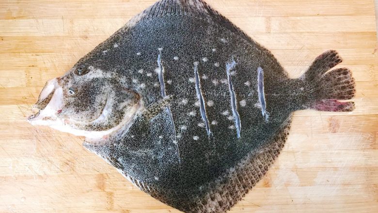 清蒸多宝鱼,处理好的多宝鱼背部划几刀 然后往鱼身上均匀涂抹食盐（划花刀是为了方便腌制过程中入味）