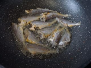 香煎小黄鱼,锅里热油后放入用厨房纸吸干水分的小黄鱼以中小火煎炸，少作翻动