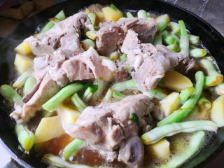 脊骨土豆炖豆角,再把脊骨带汤一起倒入锅里，一起炖，汤要多些，这样加入的就是高汤，炖出来味道才会更好，