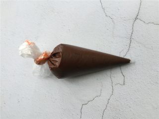 自制巧克力夹心雪糕,融化好的巧克力用裱花袋装起来扎好口放入冰箱冷冻20分钟。