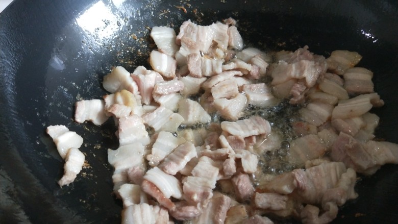 新文美食  豆角焖面,锅中放入适量油烧热，五花肉煸炒。