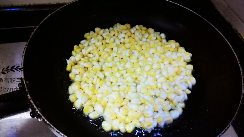 黄金玉米烙,先把油全部倒入锅里烧热，然后从锅里倒出2/3的油，在小碗里备用。把玉米粒倒入锅里，用铲子把其调整成圆饼状。要确保每一粒玉米粒都能连在一起，不要单独。中小火煎三分钟，不要用铲子动玉米粒，轻轻晃动锅，让玉米粒定型。