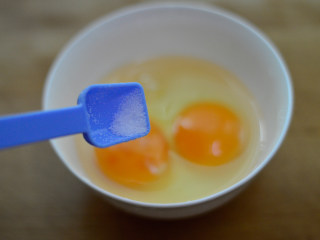 胡萝卜木耳炒鸡蛋,鸡蛋打入在碗中，调入少许盐