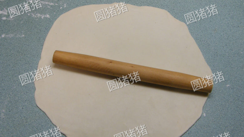 美味京都肉饼,案板上洒干粉，将1/2面团擀成约2-3mm厚大圆饼。