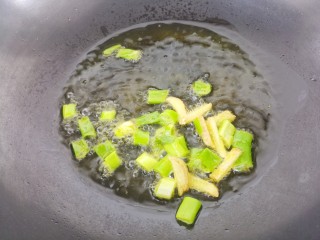 土豆炖茄子,锅里热油。先把葱和姜爆香。