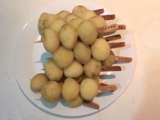 香辣土豆串,把土豆用竹签串起来，每个竹签串3个土豆