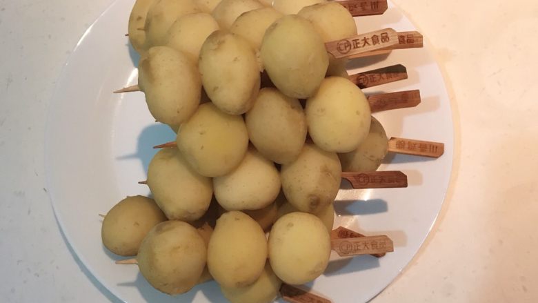 香辣土豆串,把土豆用竹签串起来，每个竹签串3个土豆