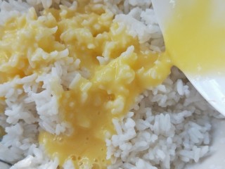 虾皮秋葵黄金炒饭,打散的蛋液淋在米饭上拌均匀