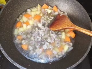 咖喱牛腩盖浇面,把炖煮好的牛腩和汤水一同倒入锅中（香叶和姜片弃之）