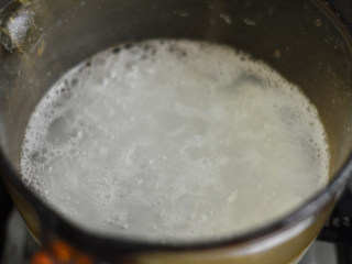 南瓜鸡肉粥（辅食）,接着将大米淘洗干净，放入锅中煮开后用小火熬煮