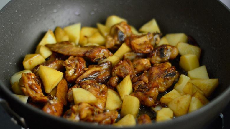 土豆香菇焖鸡翅,放入土豆块一起煎炒出香味
