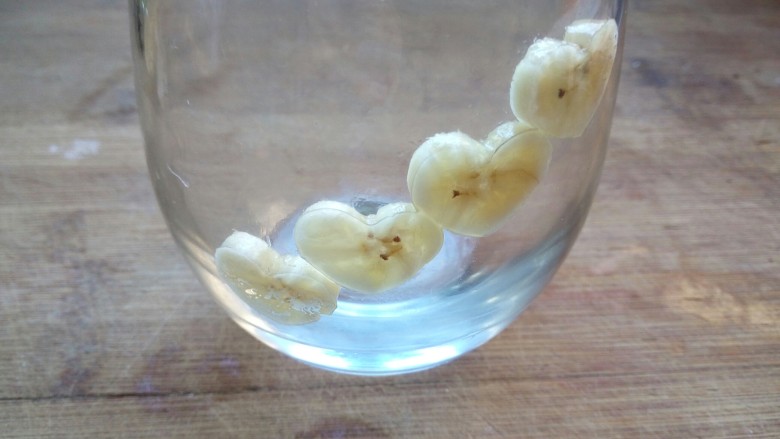 香蕉芒果思慕雪,将心形香蕉片紧贴在杯子壁上。