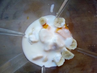 香蕉芒果思慕雪,加入酸奶，启动料理机，搅打几秒钟成奶昔状态。