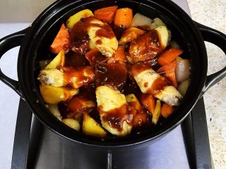 鸡翅焖锅,把调好的酱汁淋在鸡翅上，再盖上锅盖，小火焖煮15分钟左右