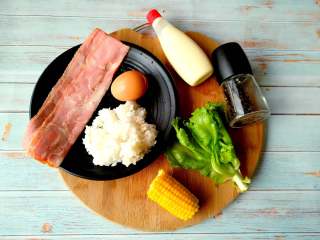 培根米饭卷,准备所需食材：培根、鸡蛋、剩米饭、熟玉米粒、生菜、黑胡椒、沙拉酱。