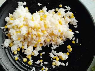 培根米饭卷,把剥离出来的玉米粒倒入米饭中，混合搅拌均匀。