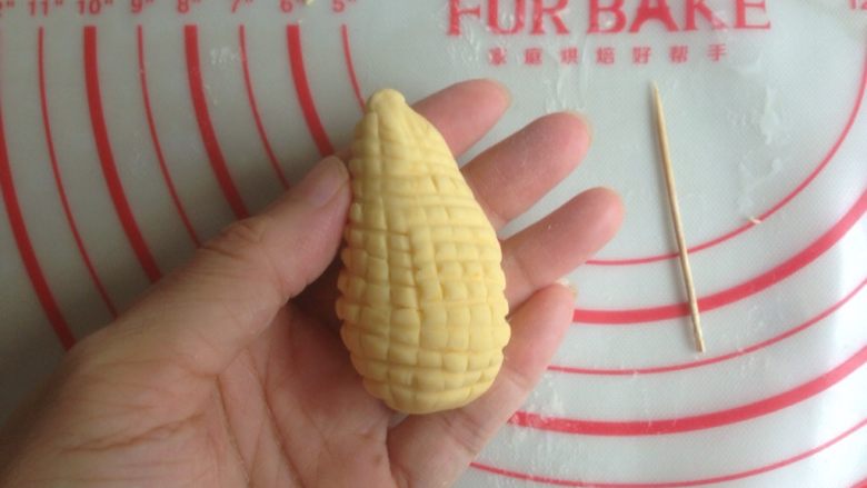 象形玉米,用牙签在表面压出格纹，放入垫有油纸或者玉米垫的蒸锅里
