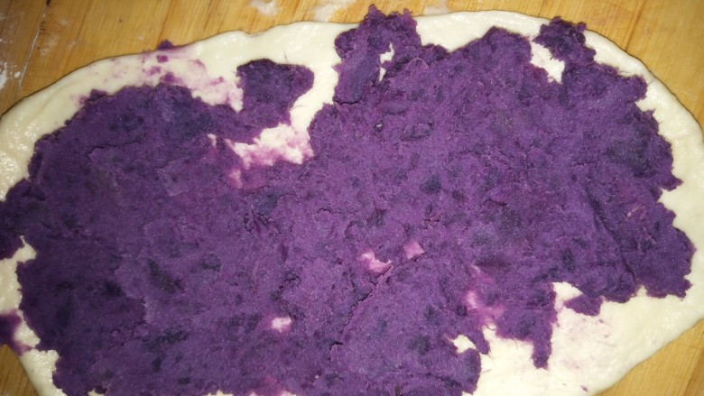 紫薯卷面包,面团发好了，（我不知道为什么我的面包机发的不大，下次自然发酵尝试一下）发好的面团揉一揉排气，揪小面剂子，做成小面团，擀开，上面均匀地铺一层紫薯泥
