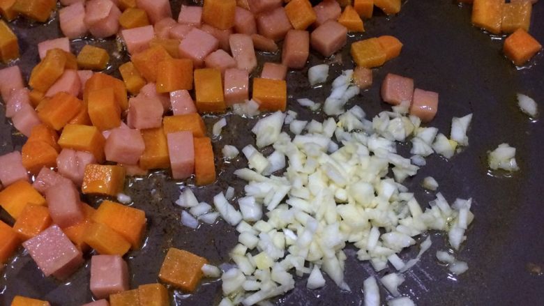 小孩最爱的下饭菜：火腿玉米毛豆杂炒,将材料拨一边，放入蒜蓉爆香。