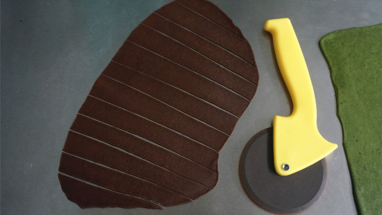 西瓜插画面包,用轮刀切割可可面片，切成条状。
