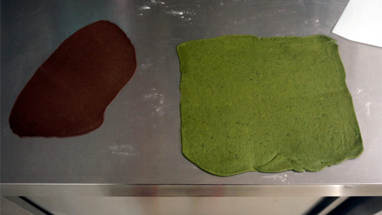 西瓜插画面包,将绿色和剩余的可可面团分别擀成面片，其中绿色的面片21*22厘米，可可面片随意。
