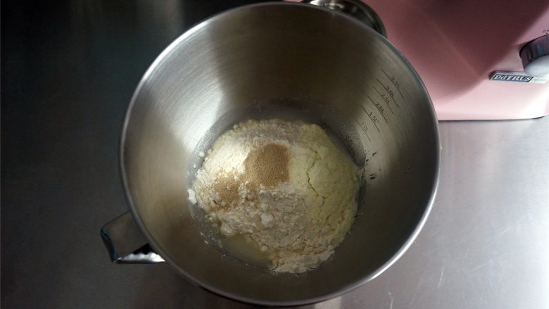 西瓜插画面包,将面团食材中除黄油外的食材放入厨师机，先低速1档和面至无干粉状态，然后转3档和面3分钟。
