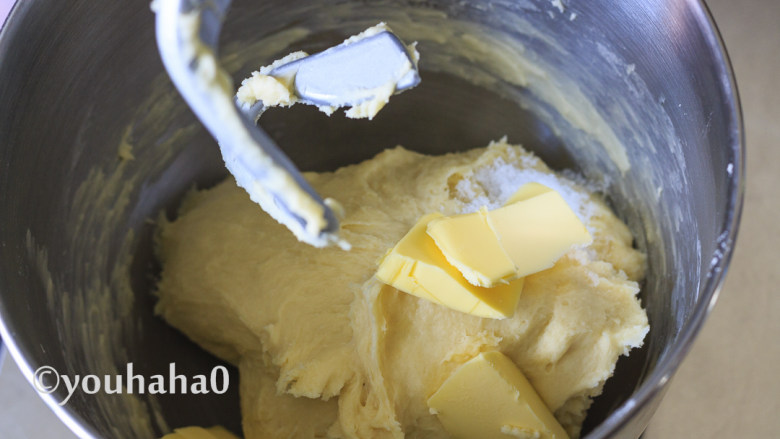 汤种牛奶吐司,先用厨师机的慢速将面粉混合成团，再用中速搅打十分钟左右，放入软化的黄油和盐继续搅打。