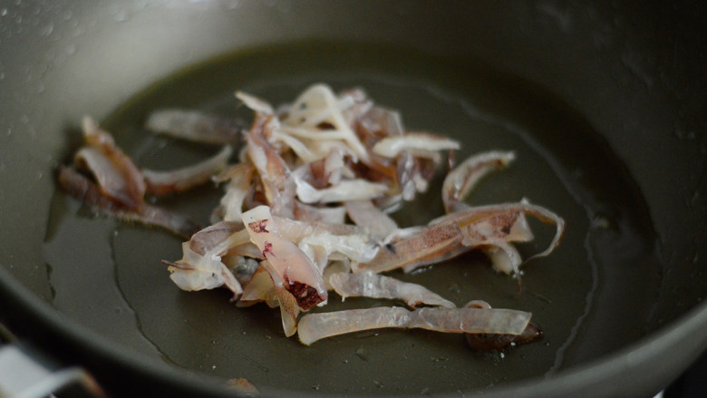 鱿鱼香菇烩饭,锅里烧热油，放入鱿鱼丝煎炒
