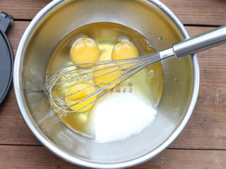 黑芝麻蛋卷,鸡蛋敲入盆中，加入玉米油、盐和细砂糖