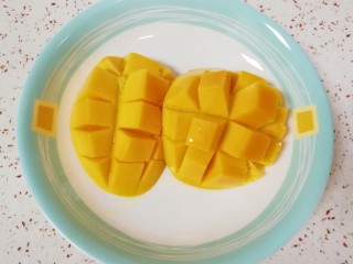 椰汁芒果西米露,焖西米的时候，把芒果洗干净，沿着果核对半切开，切花刀。
