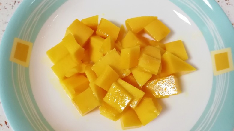 椰汁芒果西米露,将芒果果肉切成小块放在盘子里备用。